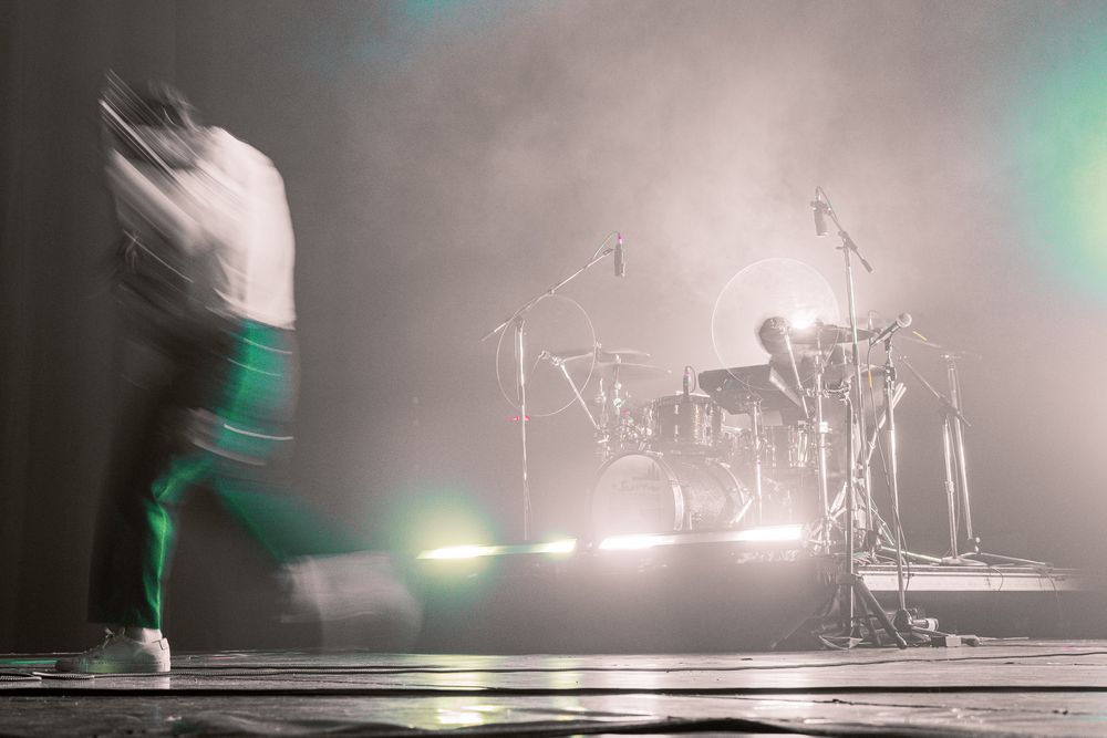 Atmospheric stage setup with instruments and equipment silhouetted in misty lighting.