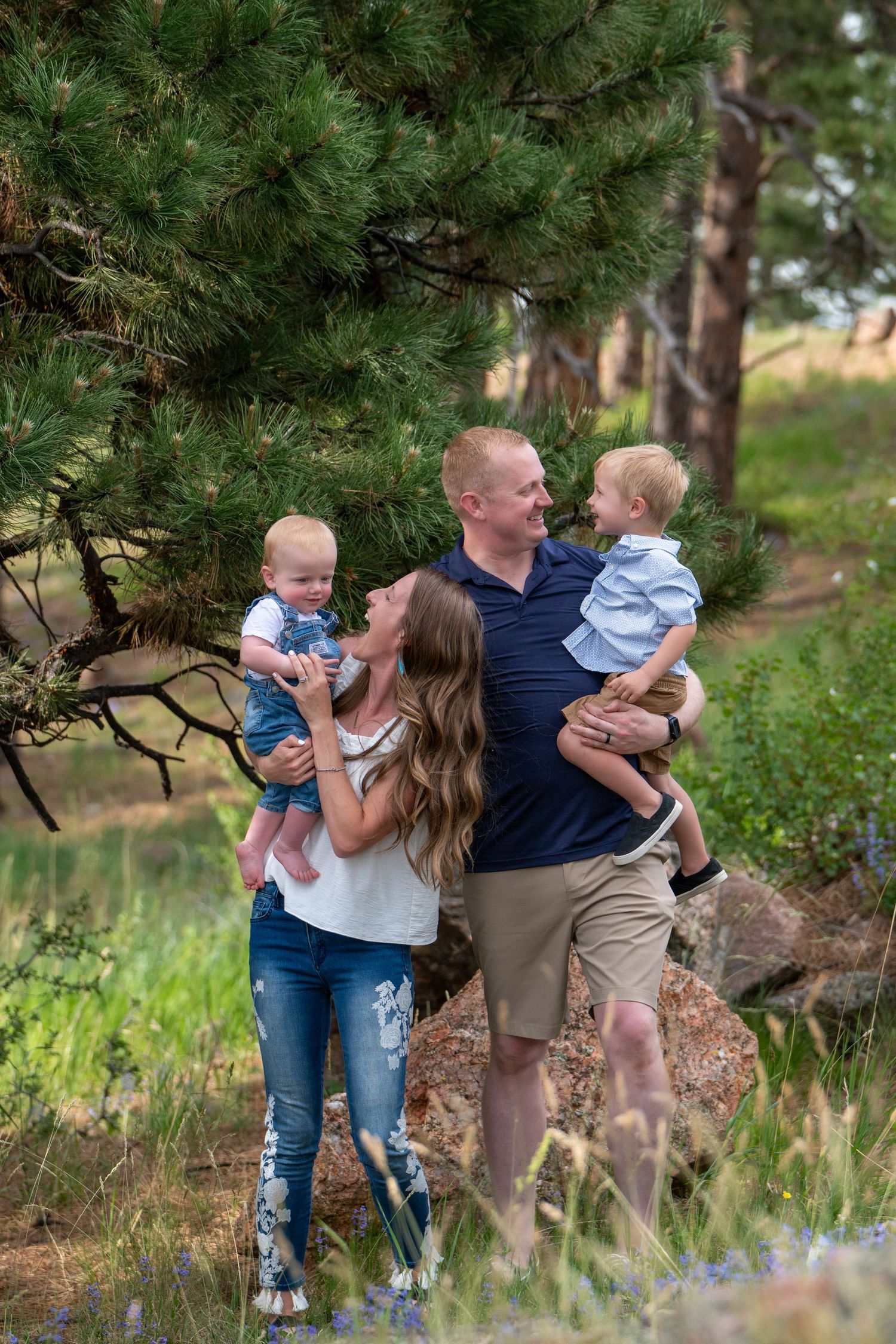 Family enjoying outdoor moment together by pine trees in natural setting.