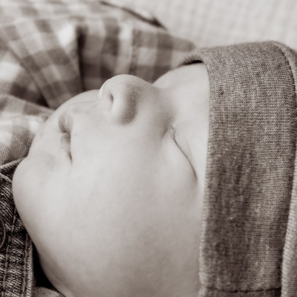 Black and white artistic portrait series showing a person resting on a pillow in multiple similar poses.