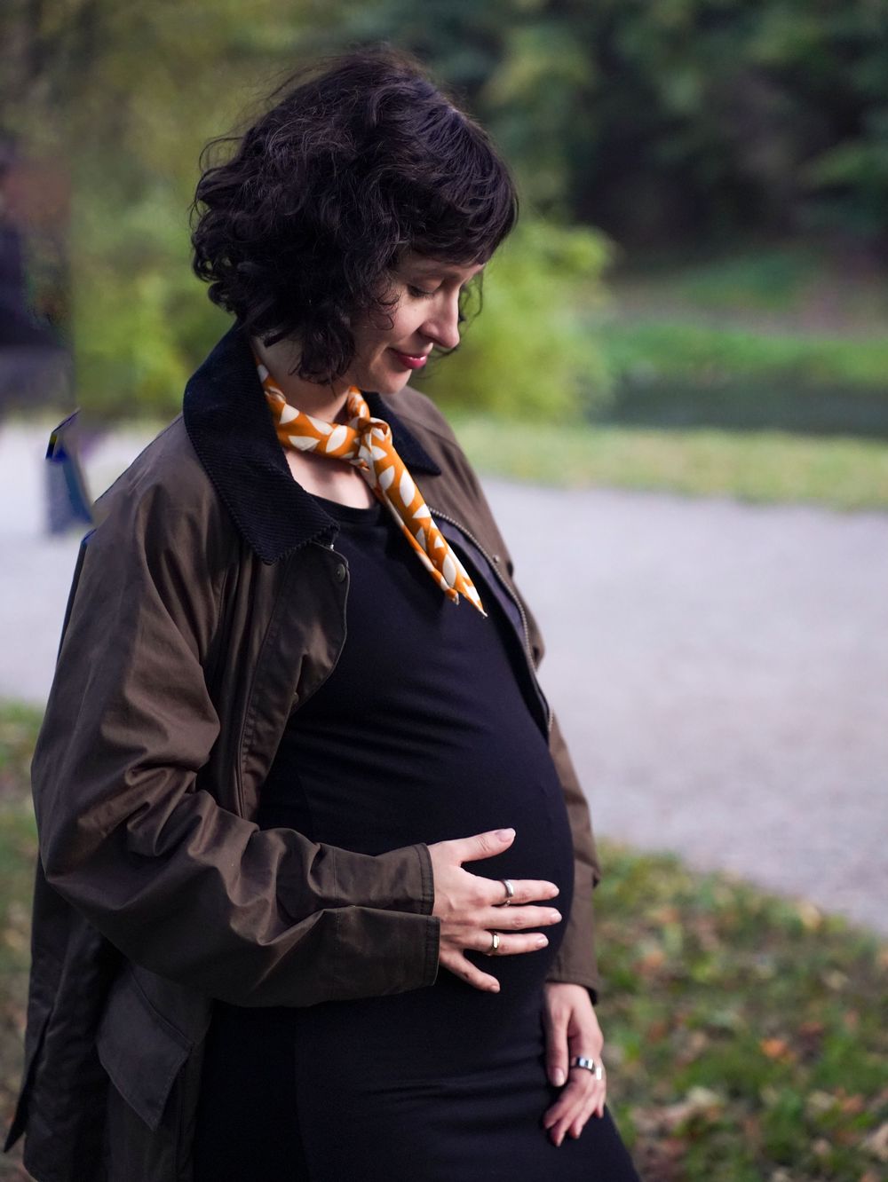 A pregnant woman looks at her belly.