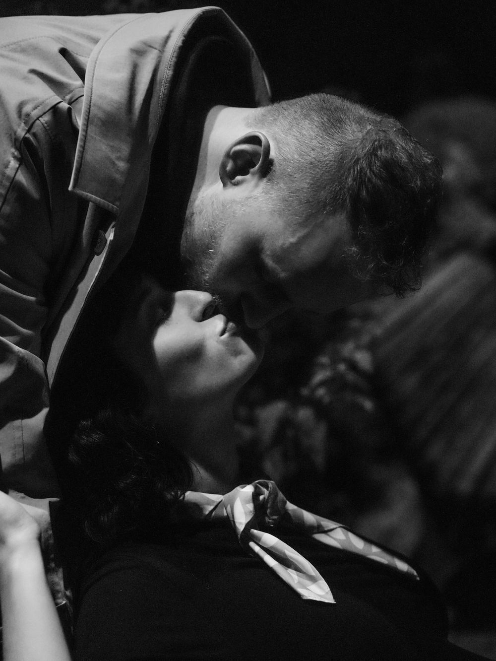 A man kisses a pregnant wife.