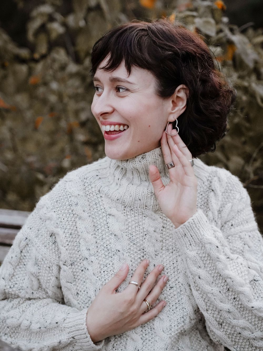 A pregnant woman with a grey sweater.