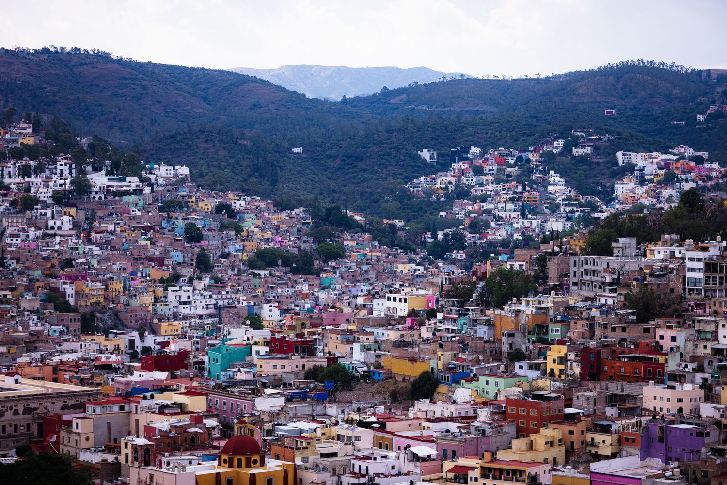 Colorful panoramic cityscape showing hillside houses and buildings in Mexico.