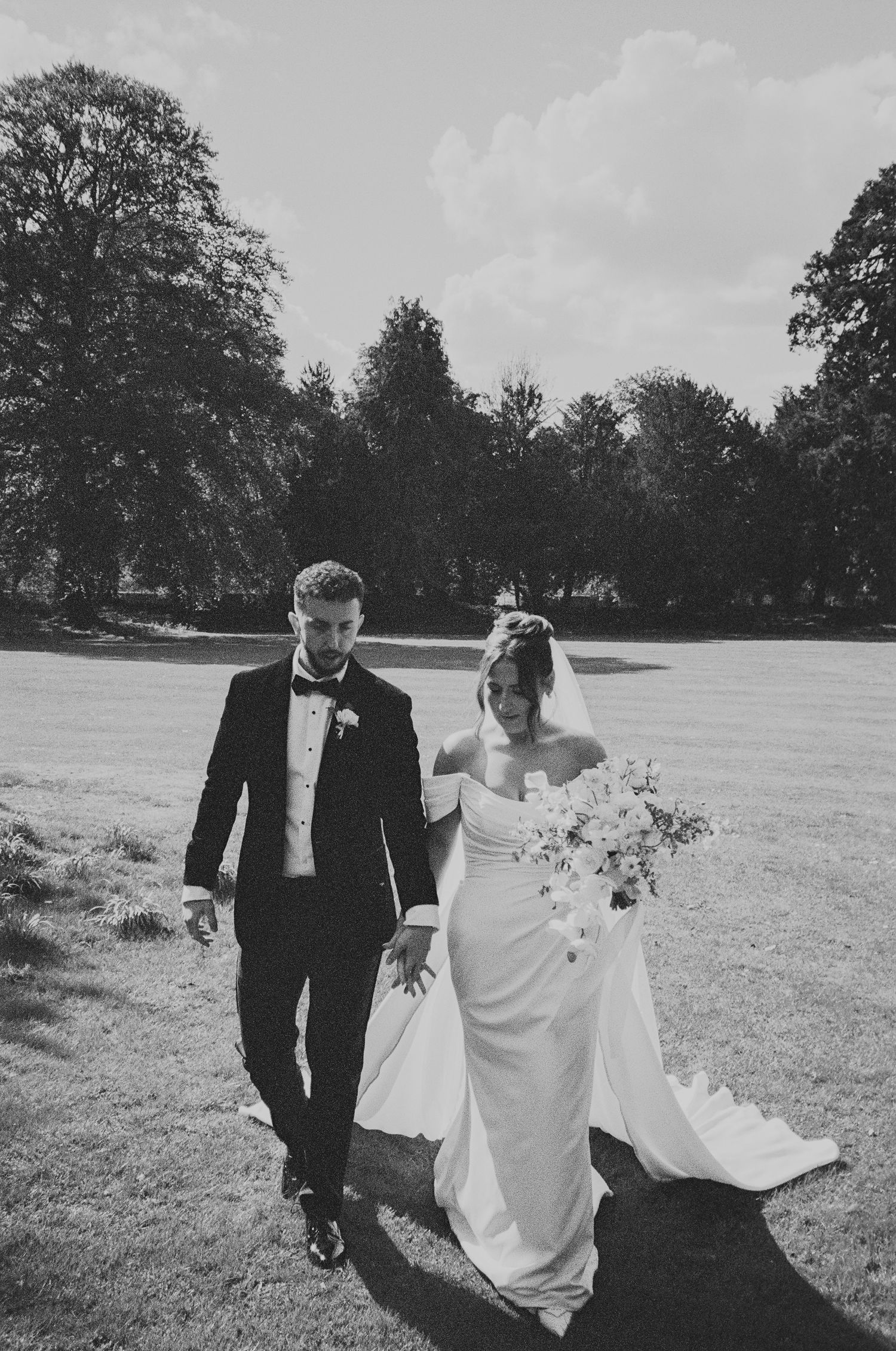 A black and white photo series showing a figure crouched near a mirror on a patterned carpet, at Surrey wedding venue.