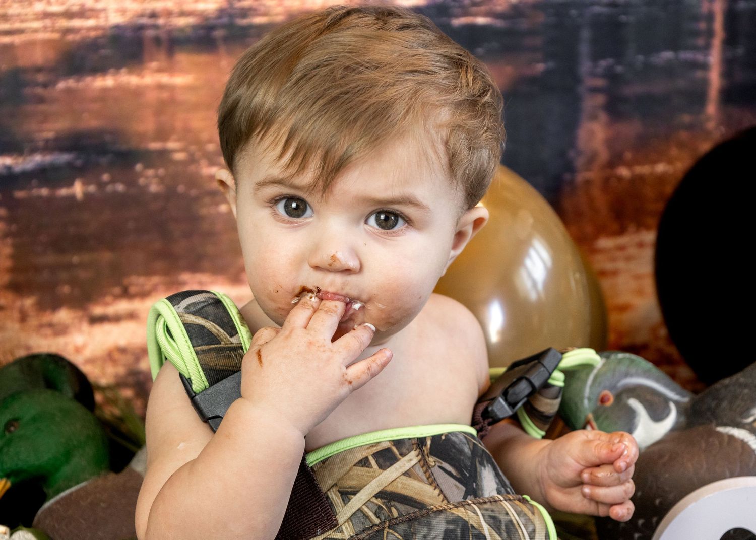 Rustic themed birthday photoshoot with woodland elements and decorative balloons.