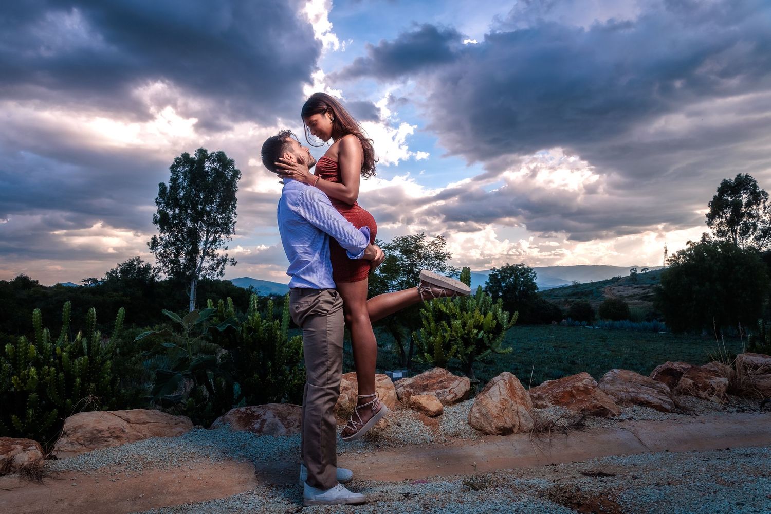 Dramatic sunset engagement photos with mountain landscape in the background.