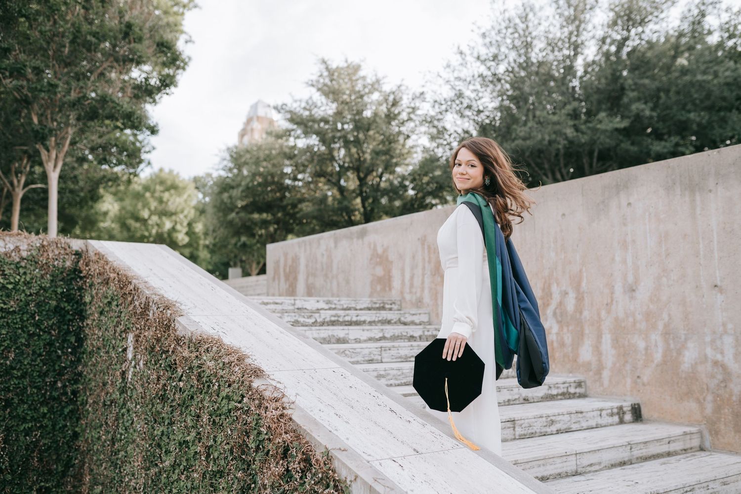 Baylor medicine PhD grad in Dallas Fort Worth posing on stairs.