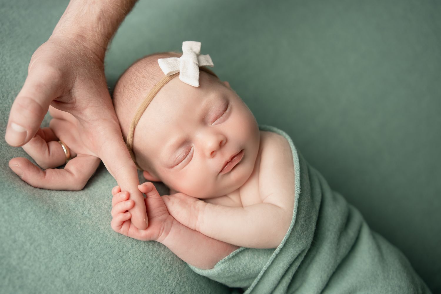 Newborn holding her dads finger