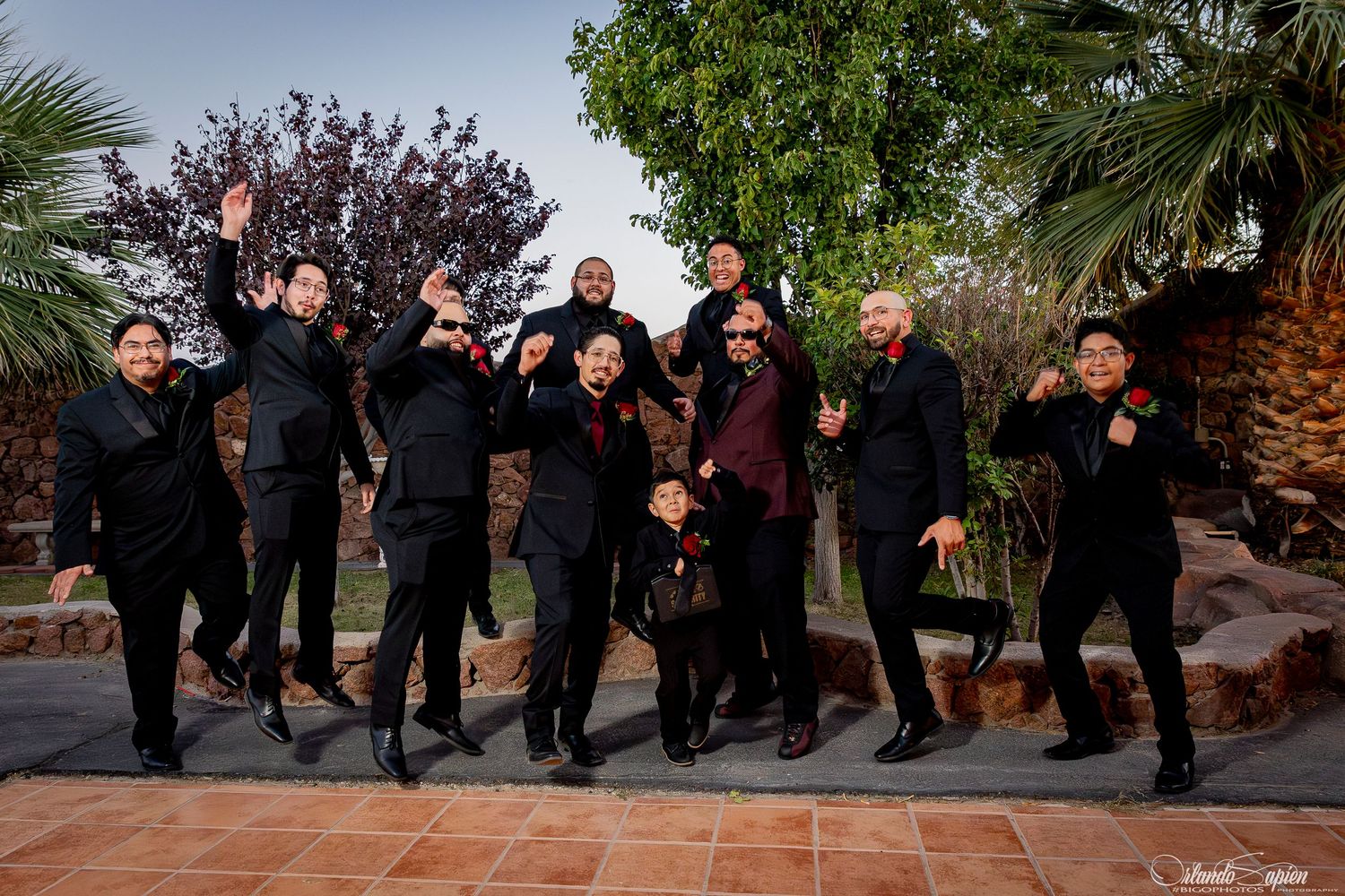 Group photo sequence showing people in black attire jumping together outdoors.