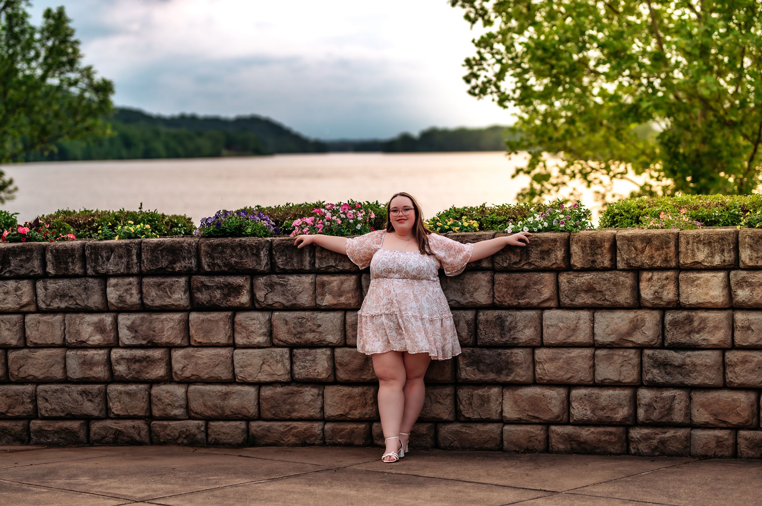 Stone wall overlook provides perfect vantage point for enjoying the scenic river view.