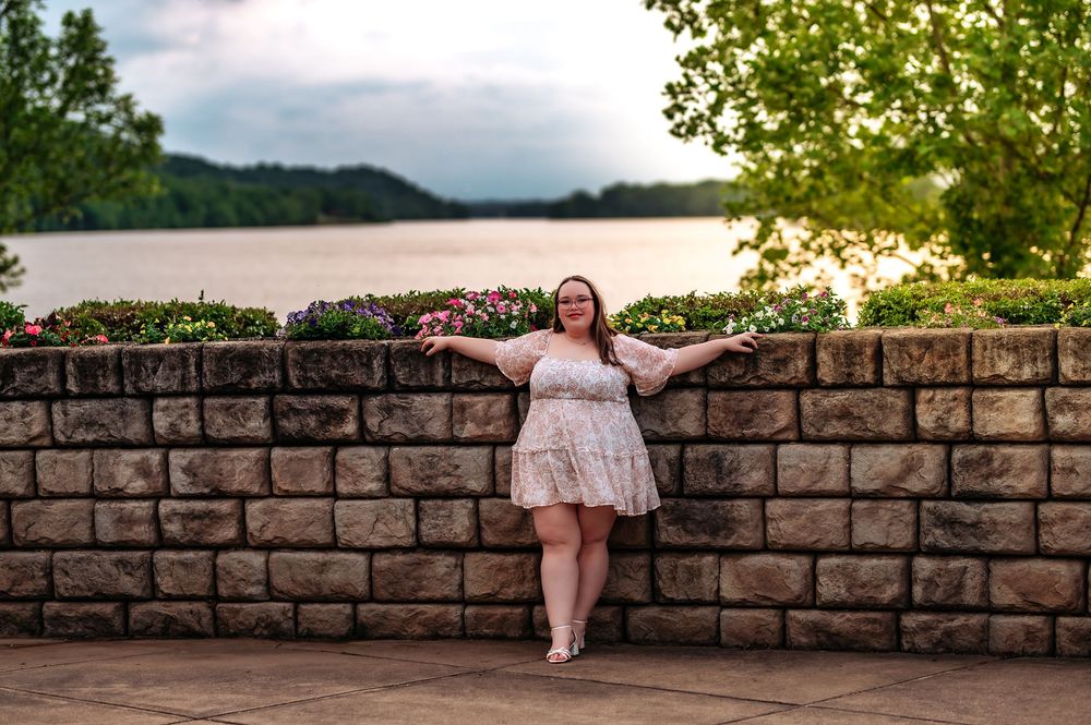 Stone wall overlook provides perfect vantage point for enjoying the scenic river view.