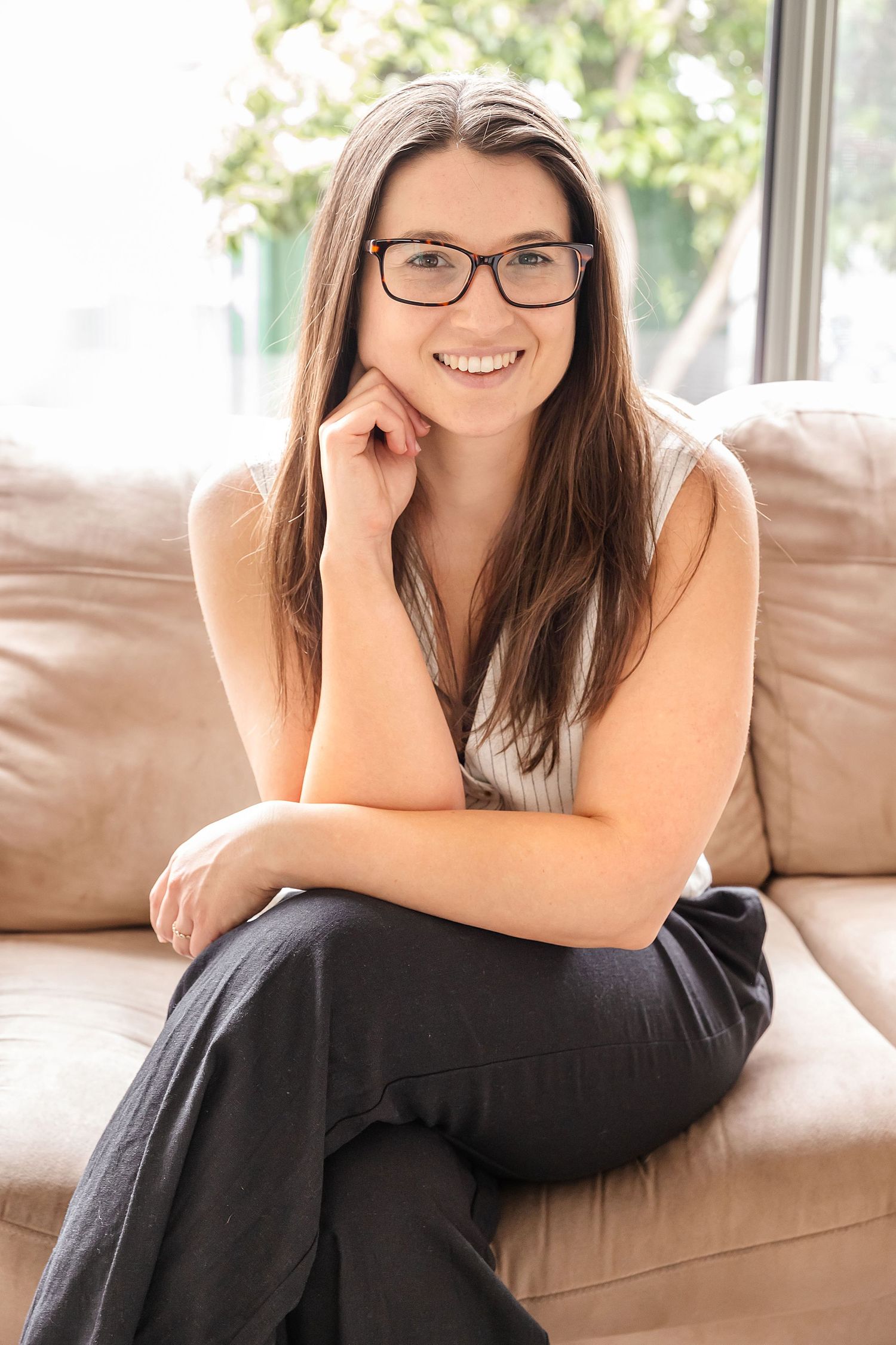 Professional corporate headshot of a businesswoman smiling on a neutral studio background, taken by an Adelaide business photographer.