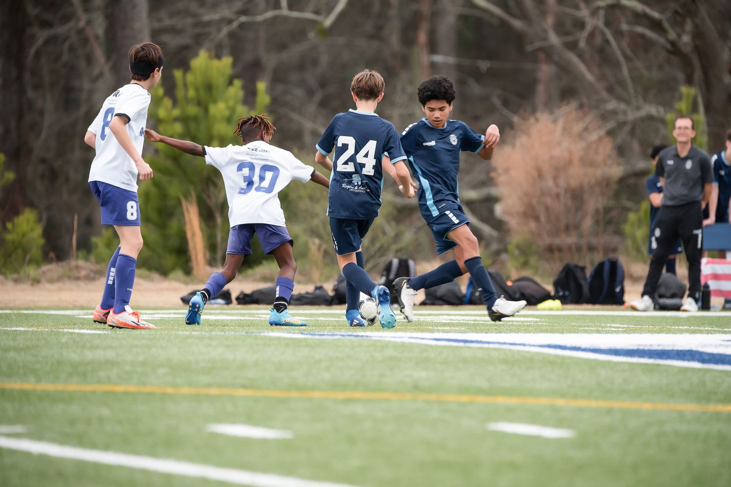 Soccer match action sequence showing players competing for possession on the field.