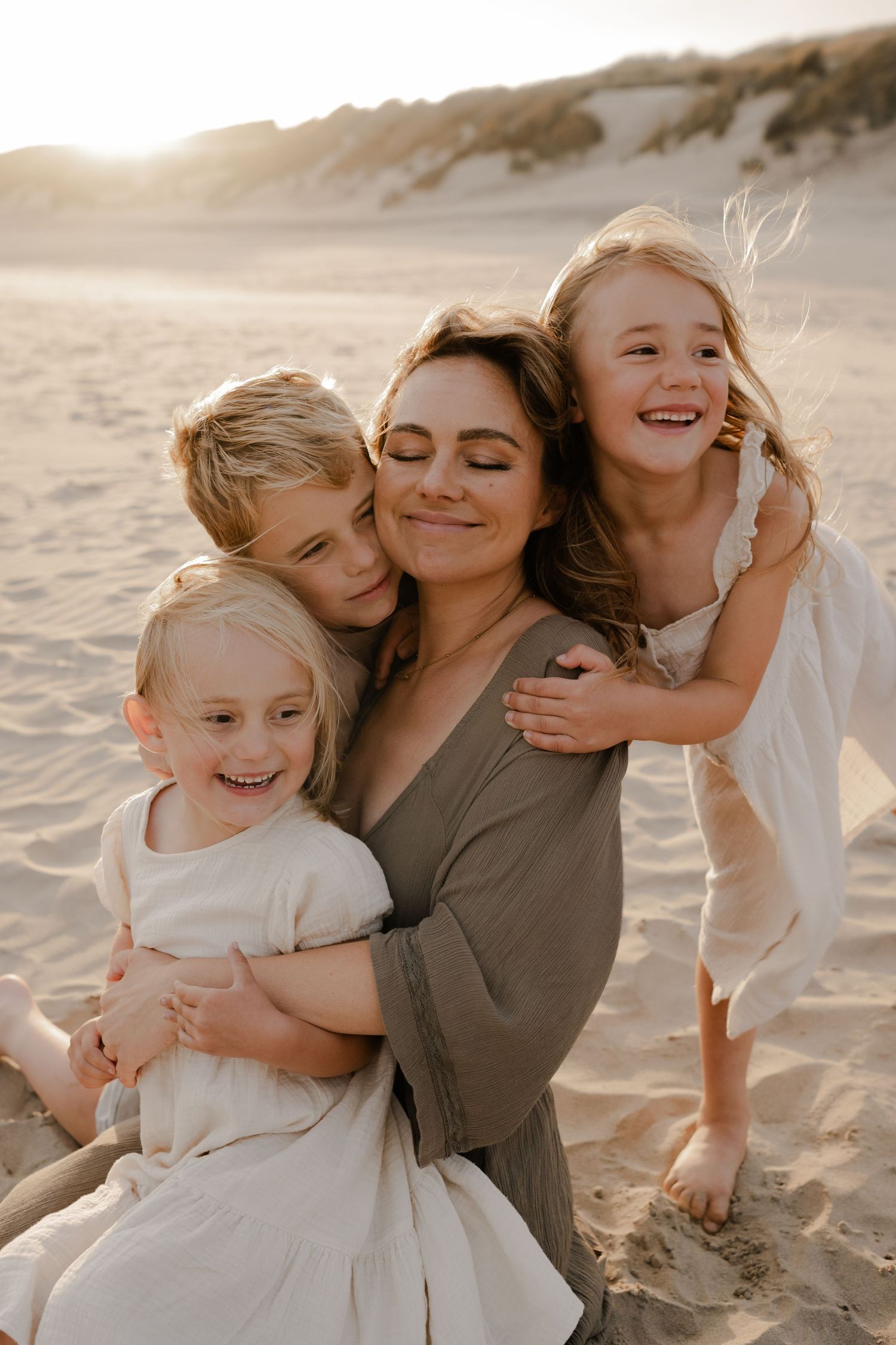 a mother surrounded by her kids, Camber Sands beach at sunset, Kent family photographer