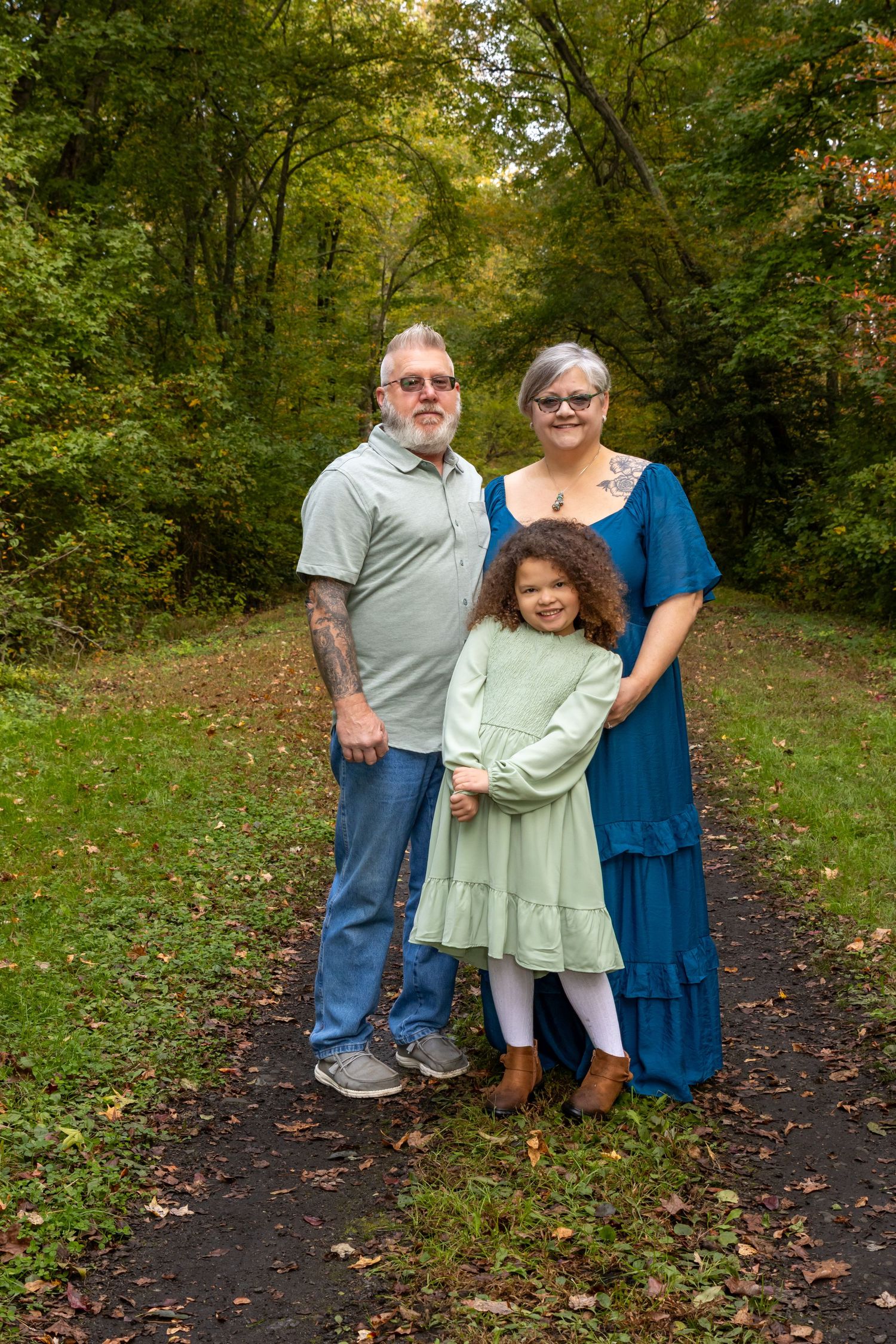 grandmother and grandfather with their granddaughter on a wooded path. Salem and Gloucester County family Photographer