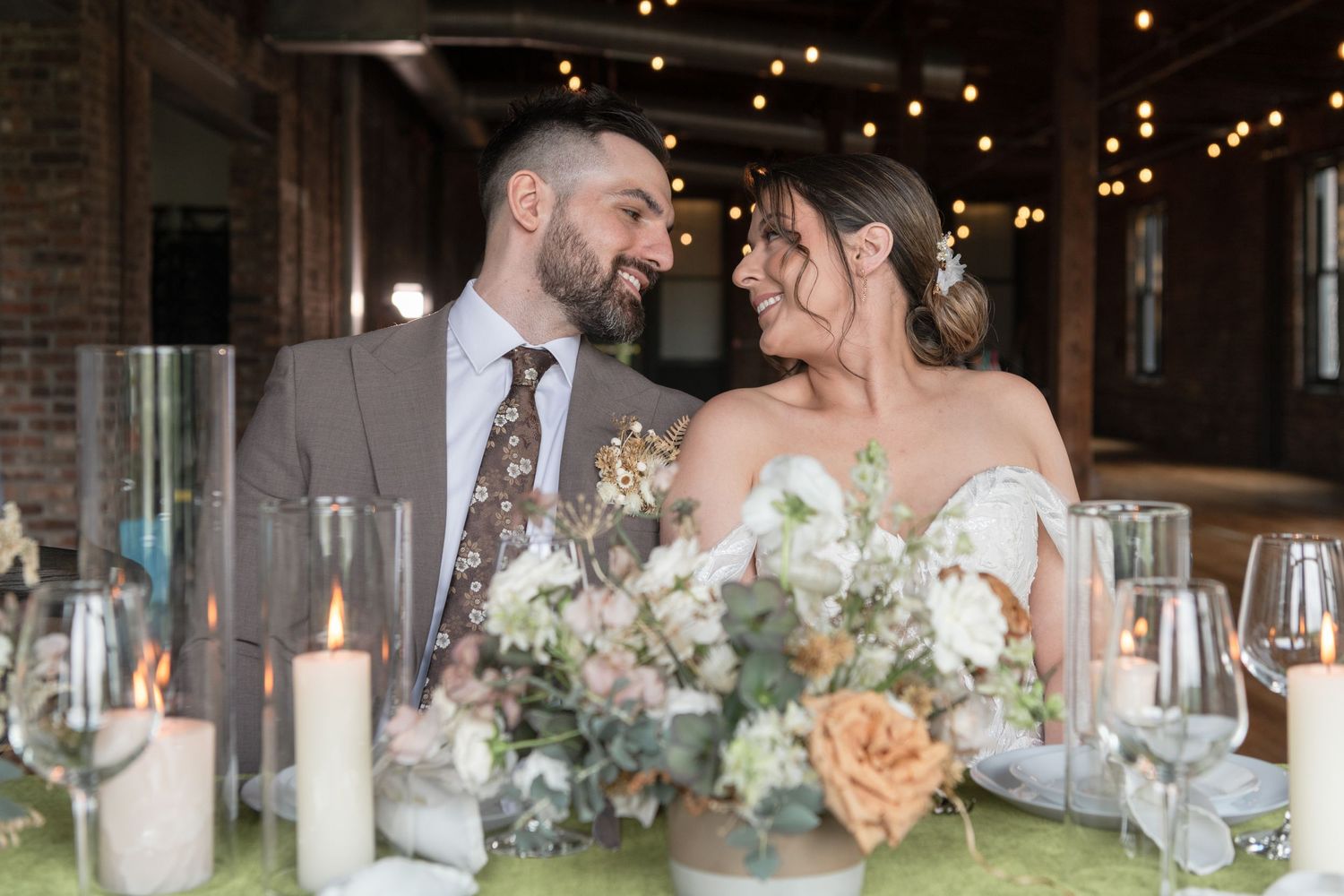 Reception dinner table setting with couple and romantic candlelight.