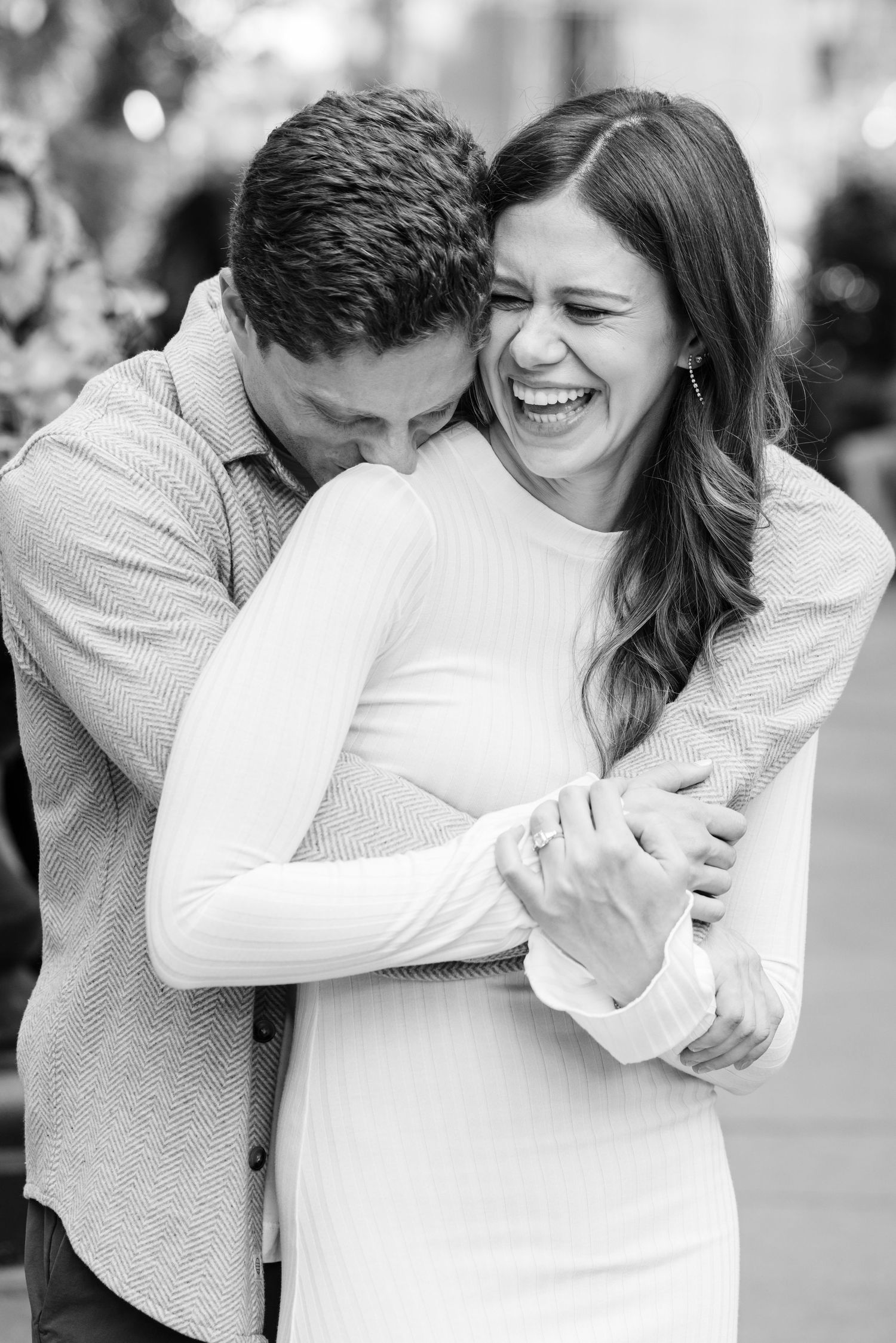 A sequence of black and white photos showing a couple embracing and laughing together in a candid moment.