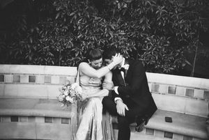 Vintage black and white photograph showing a person in formal attire dancing with a child in a dress outdoors.