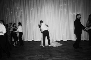 Black and white wedding reception photos show guests dancing and celebrating on the dance floor.