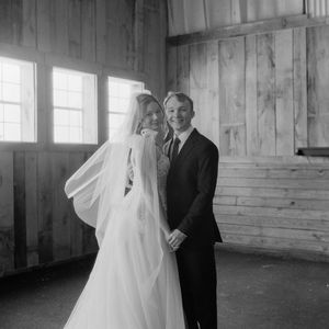 Black and white wedding portrait showing couple in rustic wooden room with natural window light.