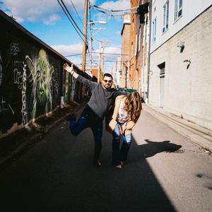 People having fun and playing in an urban alley with graffiti walls and telephone poles on a sunny day.