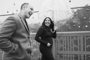 Black and white photograph of a playful group enjoying a rainy day together in an outdoor setting.