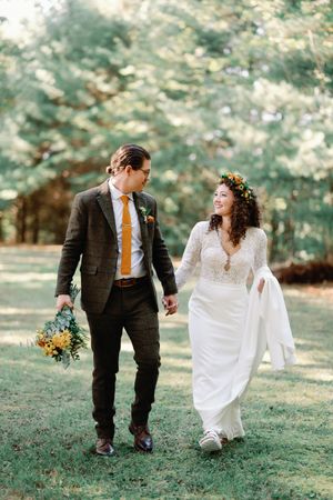 A heartwarming outdoor wedding sequence showing a couple walking and sharing joyful moments in a sunlit garden setting.