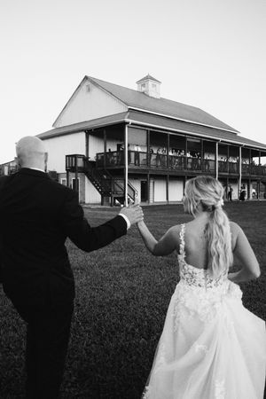Black and white wedding photograph series showing a couple in silhouette walking near an elegant barn venue.