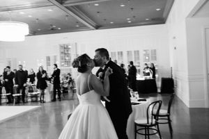 Black and white photograph showing couples dancing in an elegant ballroom during a formal wedding reception.