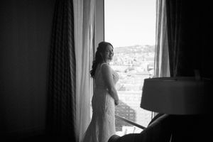 Dark silhouette of a person standing by a window, creating a dramatic contrast against bright natural light.