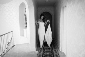 A haunting black and white photograph of a dark empty corridor with stark white walls and deep shadows.