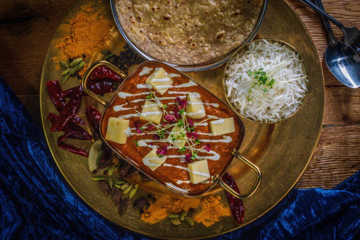A vibrant selection of delicious curry dishes served in bowls, including rich sauces, fresh herbs, and colourful spices. Restaurant photo