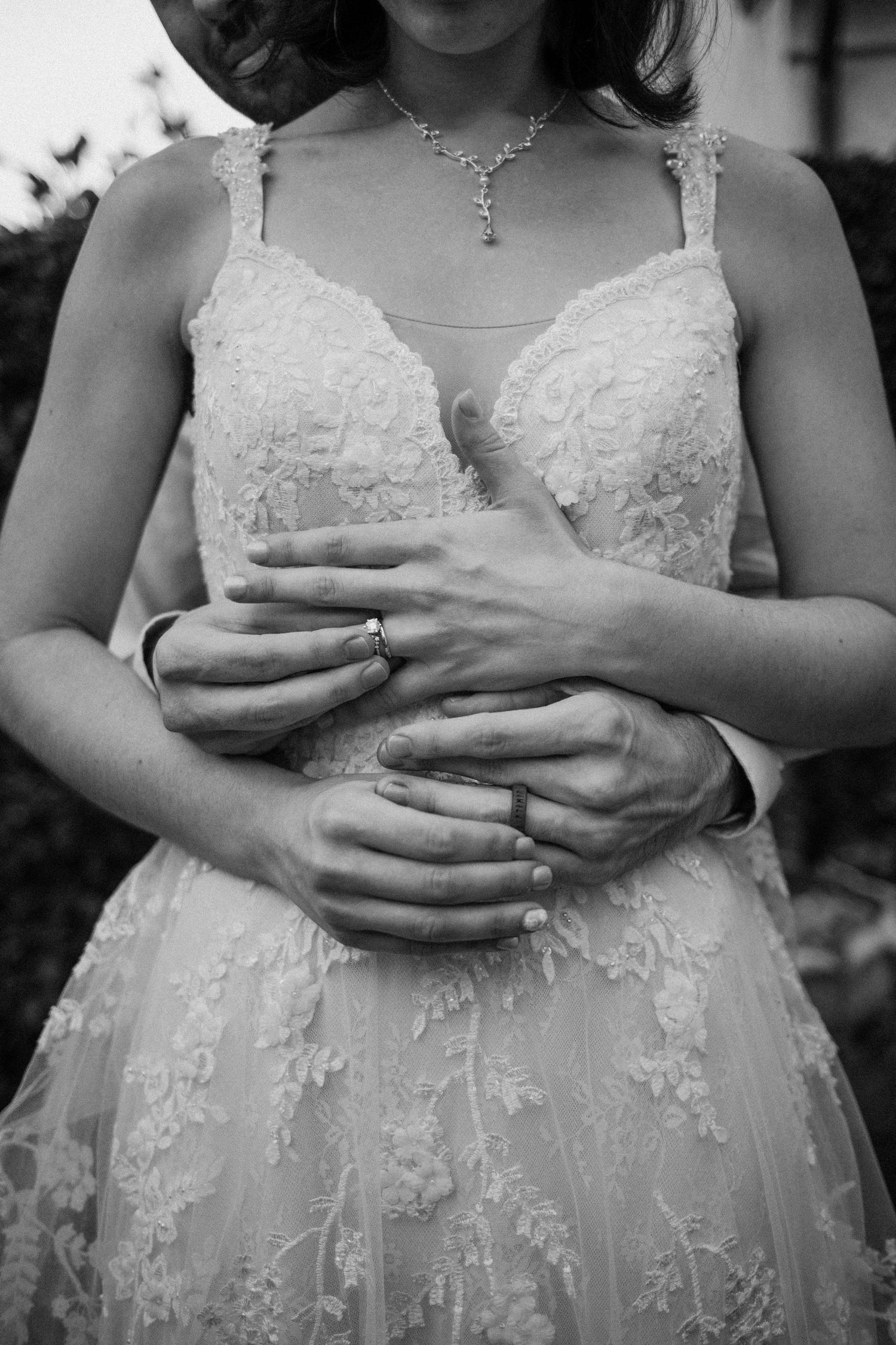 Black and white wedding photo of bride and groom exchanging rings