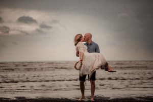 Brudpar i regn och storm på en strand i skåne