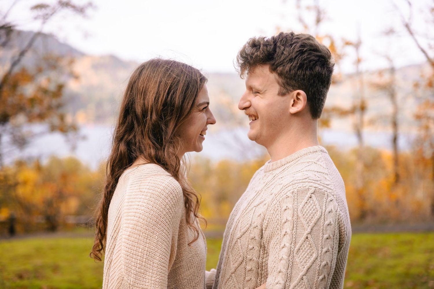A couple in cozy sweaters share an intimate moment outdoors during autumn in the Columbia Gorge in Oregon or Washington state
