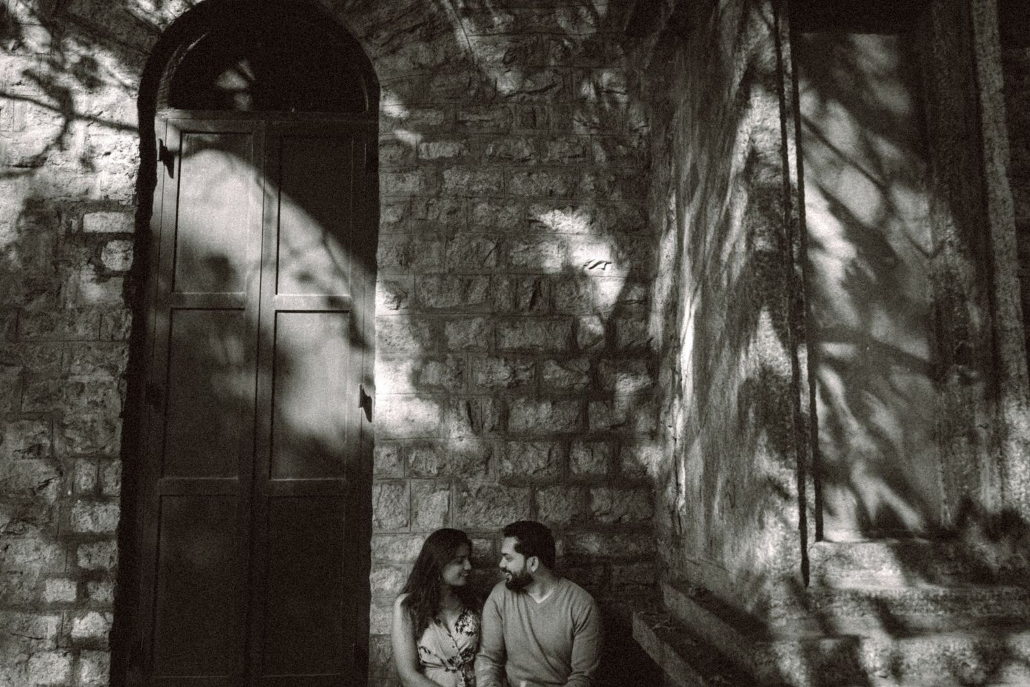 Artistic black and white portrait series against textured stone wall.