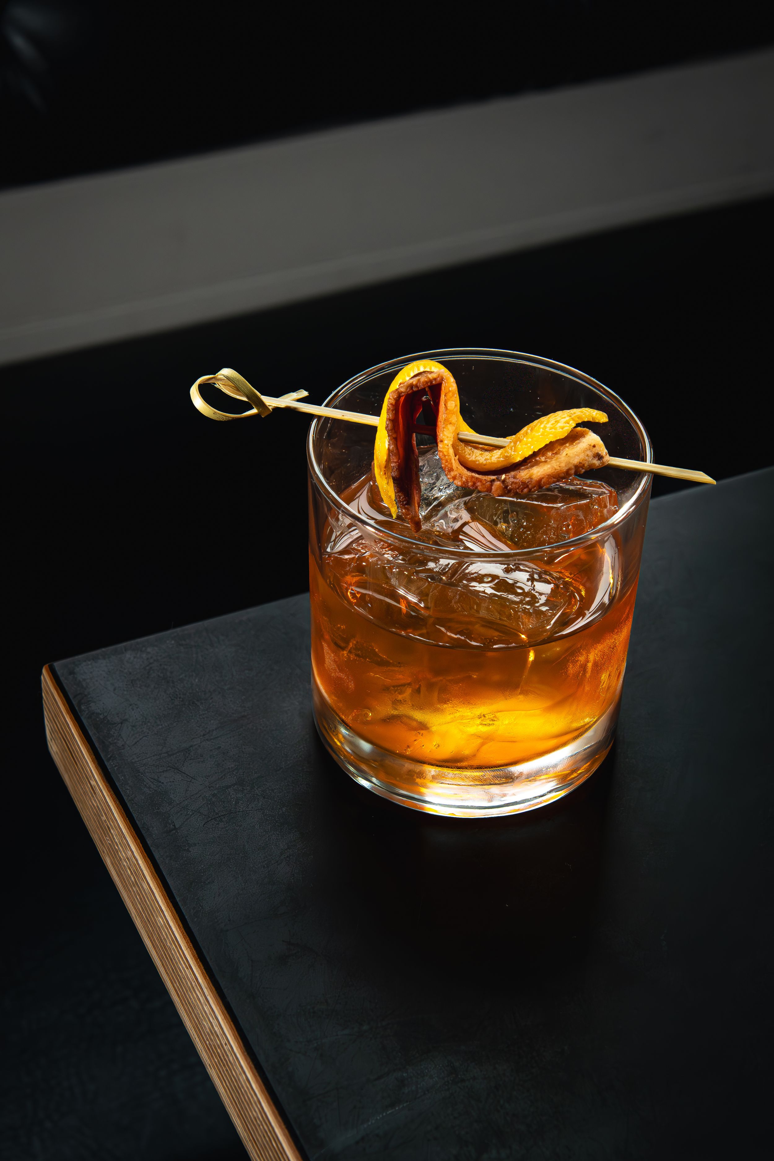 Editorial cocktail photography of a bacon fat-washed old-fashioned with orange peel garnish at Elliott’s Urban Kitchen during cocktail week