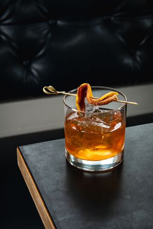 Editorial cocktail photography of a bacon fat-washed old-fashioned with orange peel garnish at Elliott’s Urban Kitchen during cocktail week