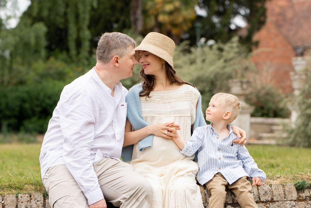 An outdoor family photo showing tender moments between parents and children in a natural setting.