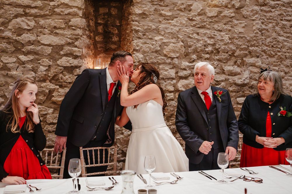 Priston Mill wedding photography Bath Somerset kiss between bride and groom during speeches