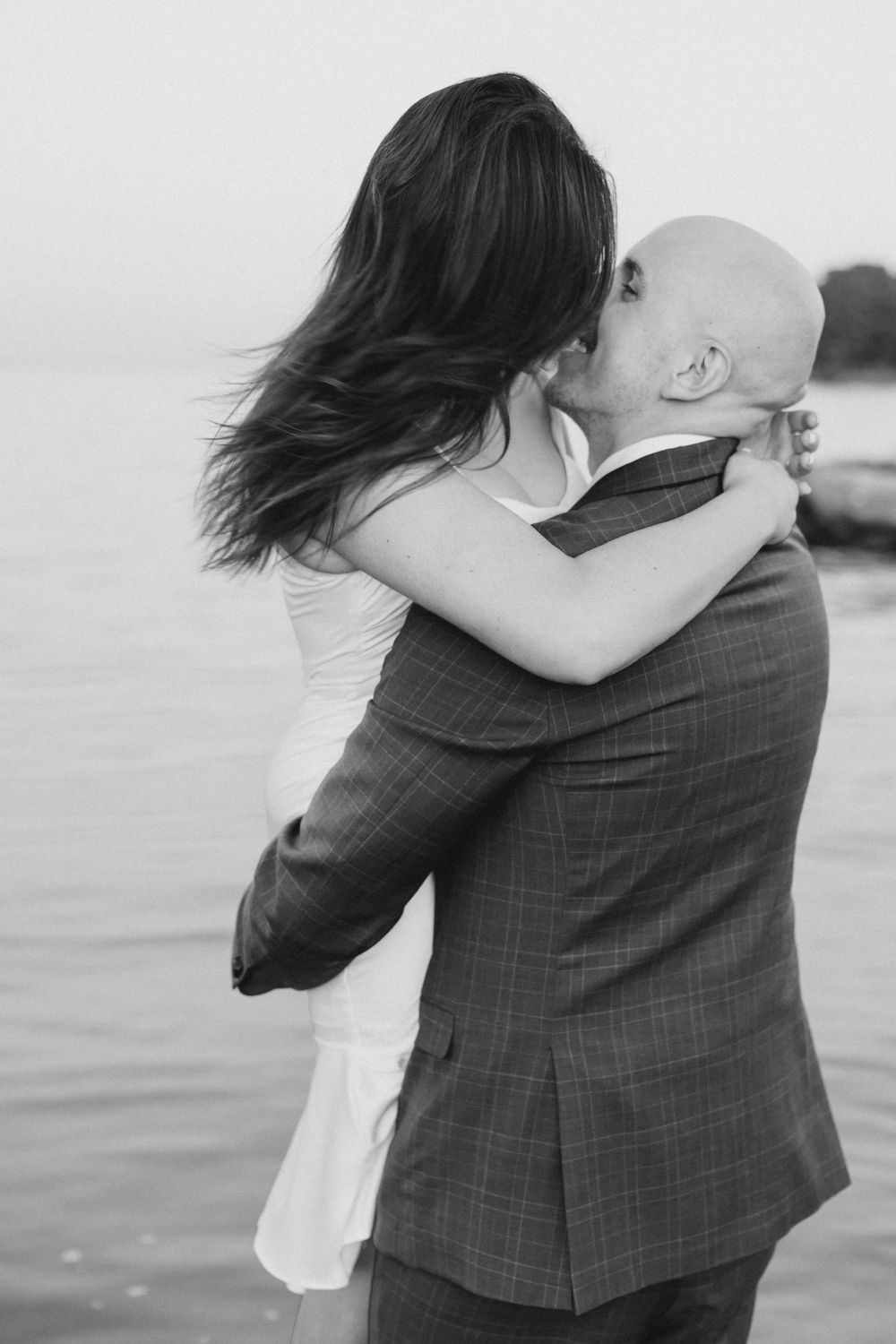 Couple by water at sunset in black and white