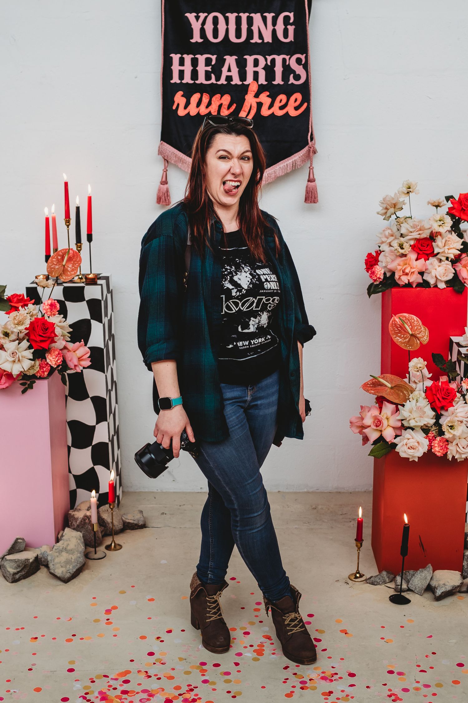 Stylish photo shoot setup with pink and red decor against a white wall featuring text signs.