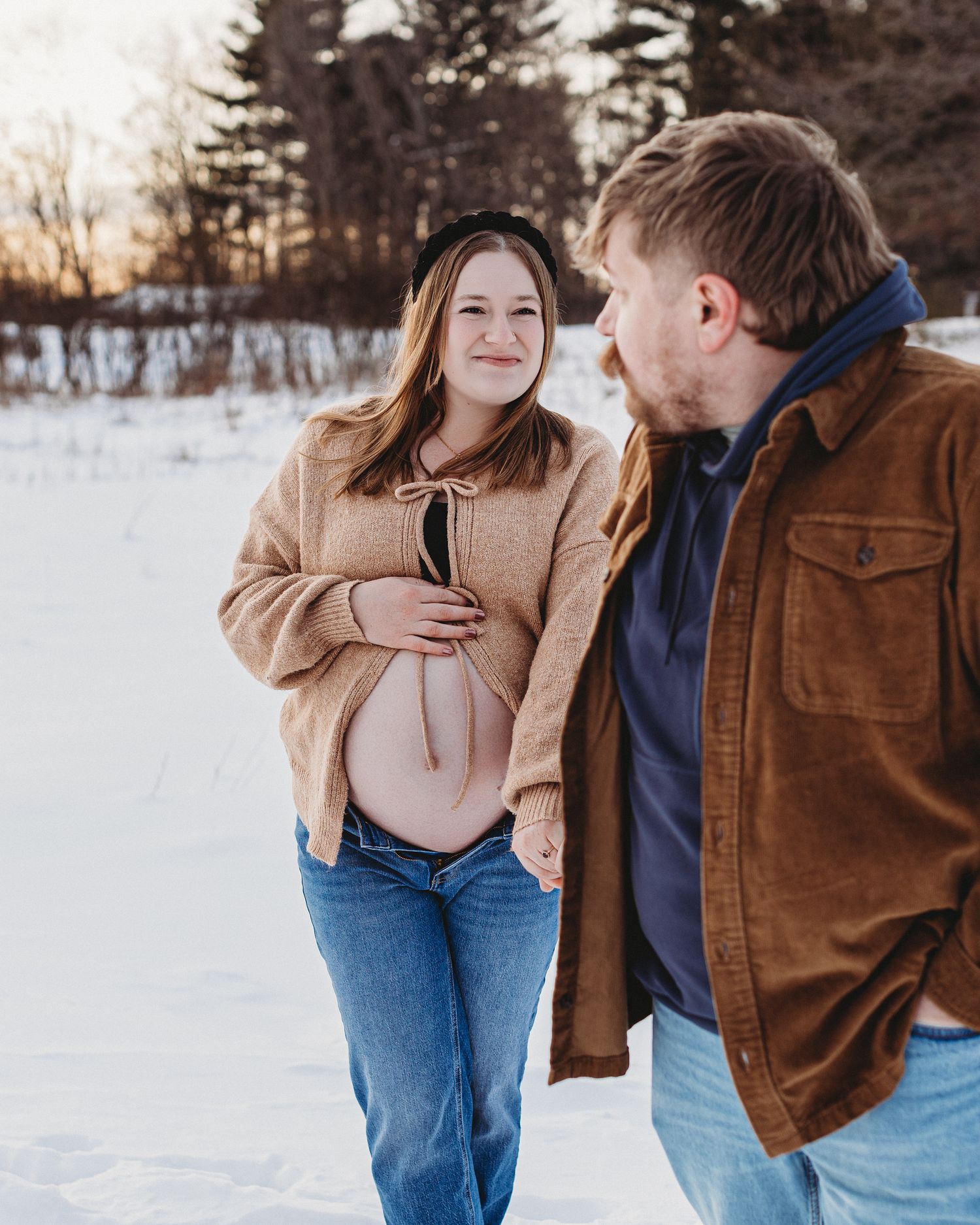 Romantic winter maternity couples session in Maine with scenic snow-covered background