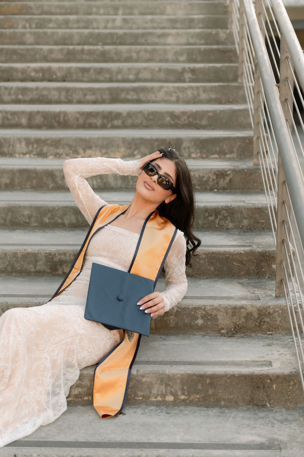 A UC Davis graduate poses on the UC Davis campus for her graduation shoot. Photographed by Shumesa Mohsin