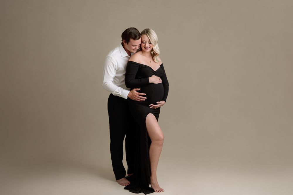 professional studio maternity portrait of kansas city couple formal wear on light backdrop