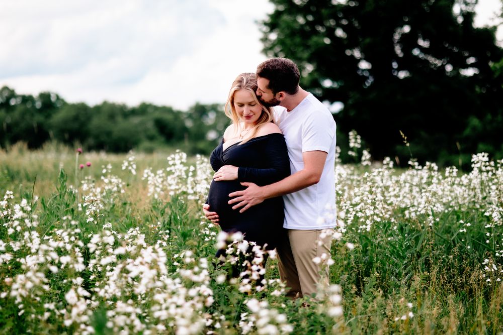couple cuddled holding womans pregnant belly lees summit