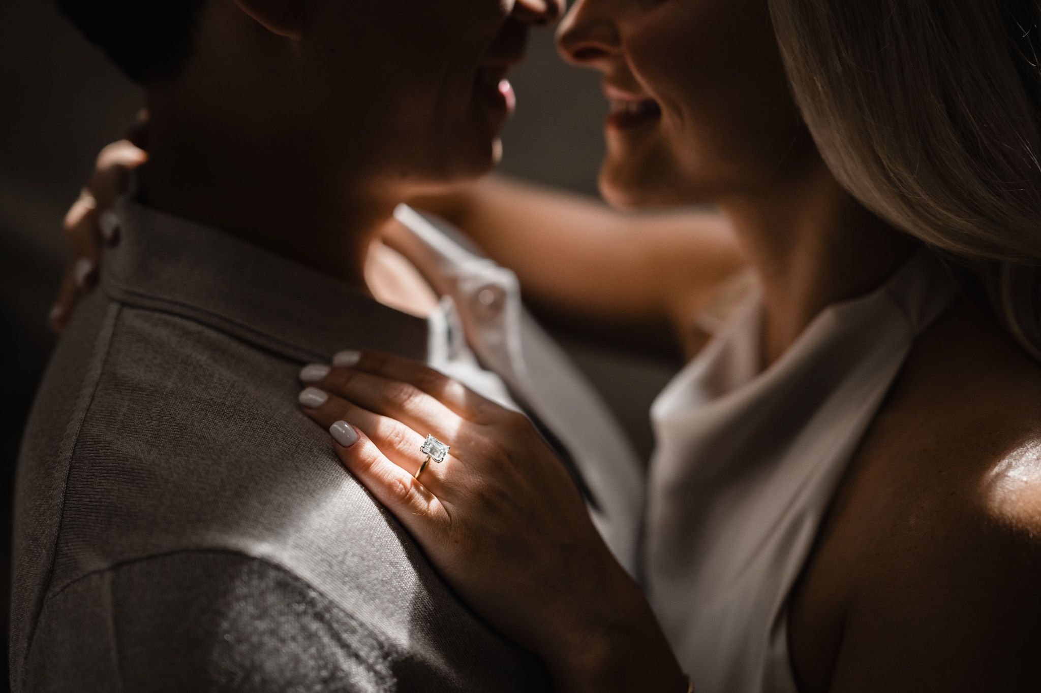 New york public library dark moody close up of the bride and groom a sliver of bright window light illuminate the engagement ring