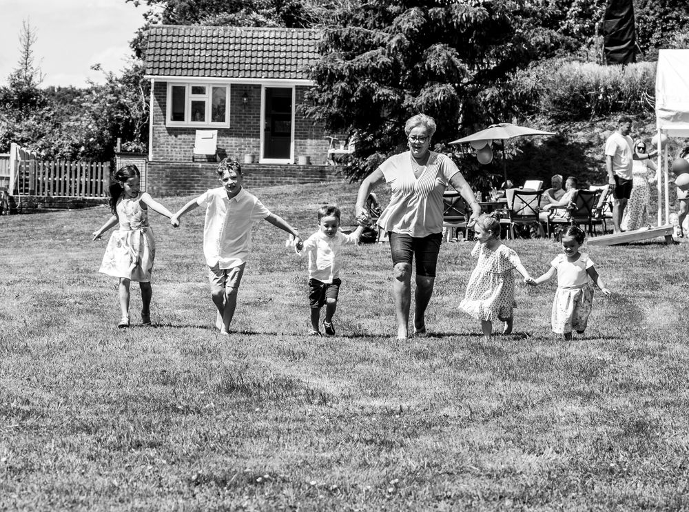 Black and white sequence showing children playing soccer on a grassy field during recreational activity.
