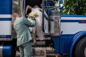 Wedding couple standing next to a vintage blue and white vehicle.