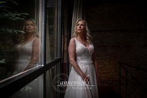 A tender moment captured in a rustic brick venue with natural window lighting.